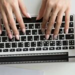 Person typing on a laptop keyboard