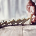 Hand stopping the domino effect