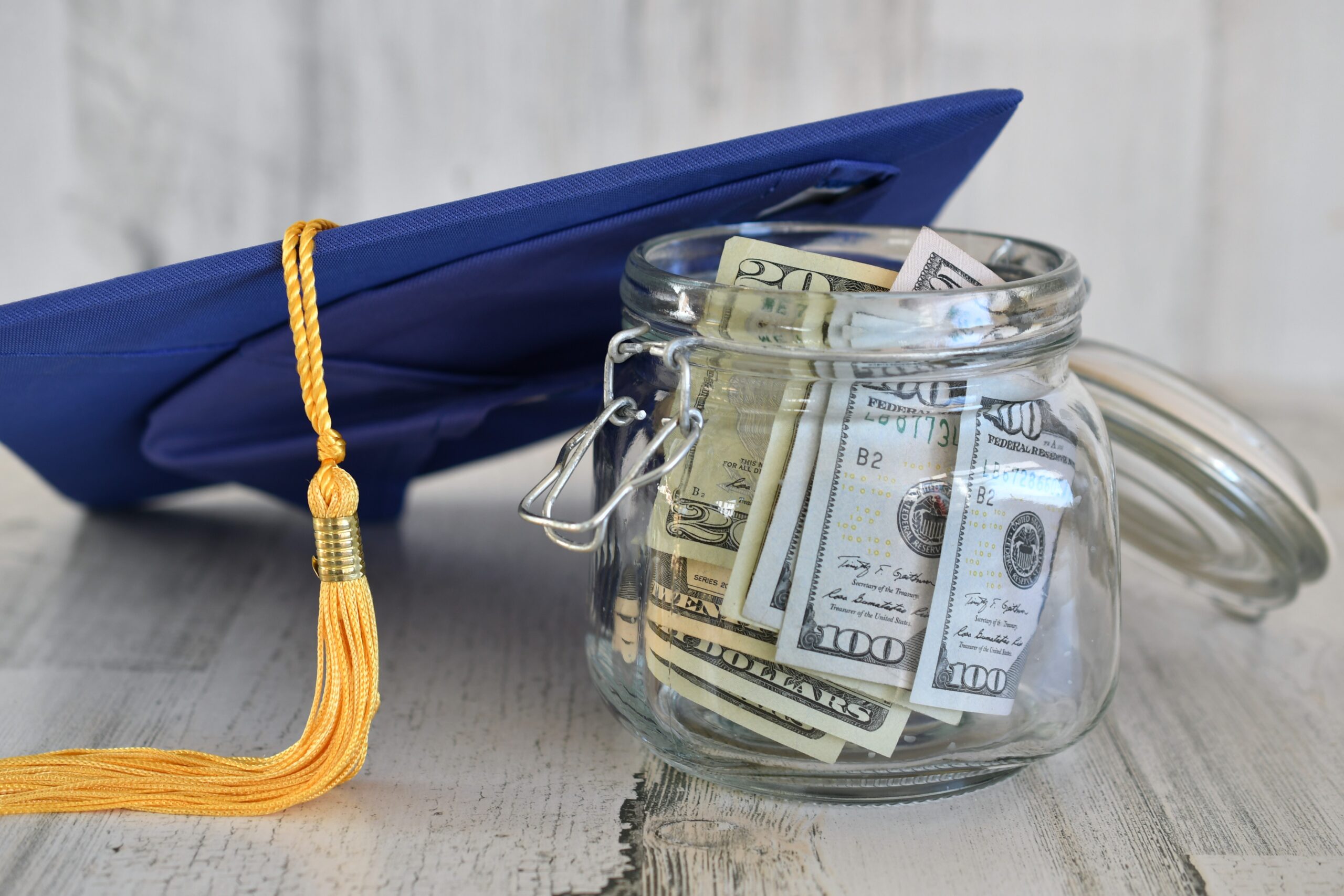 Graduation cap next to a jar of money